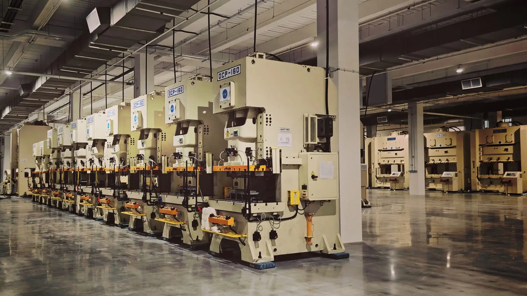 Modern metal işleme fabrikasında sıralanmış eksantrik presler ve geniş üretim alanı