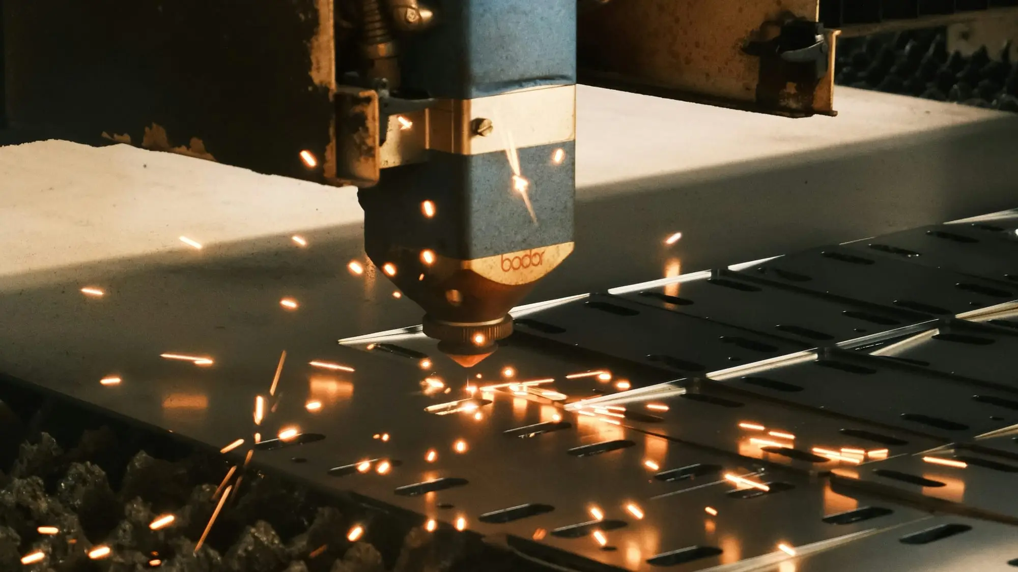 Fiber lazer kesim kafası çelik sacı keserken etrafa kıvılcımlar saçılıyor